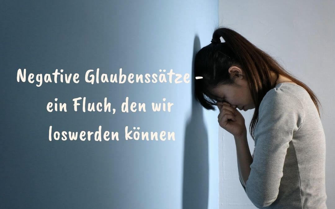 Eine verzweifelte Frau lehnt mit dem Kopf an der Wand und daneben ist ein Spruch Negative Glaubenssätze - ein Fluch, den wir loswerden können