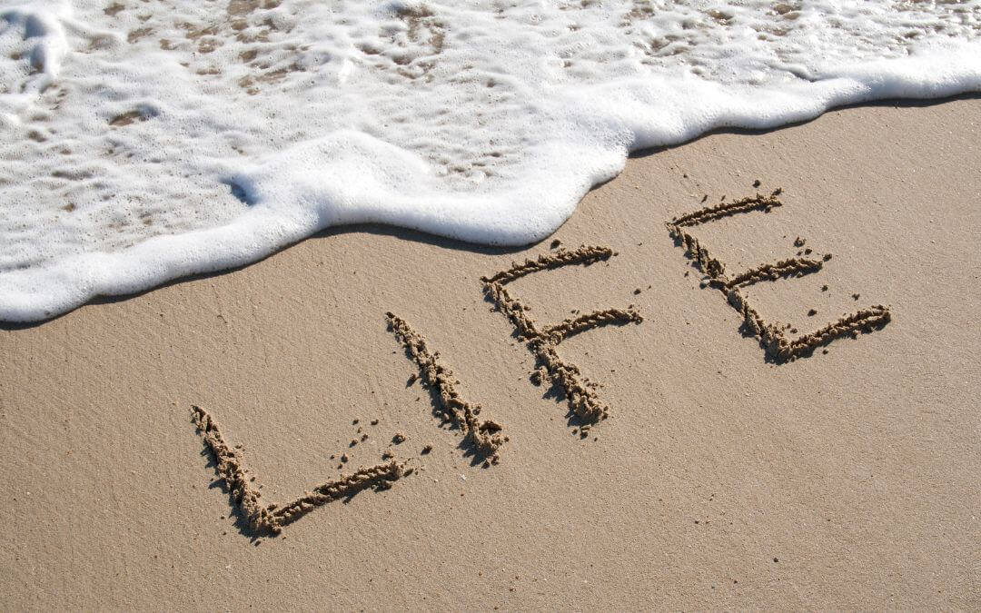 Im Sandstrand steht das Wort Leben auf englisch